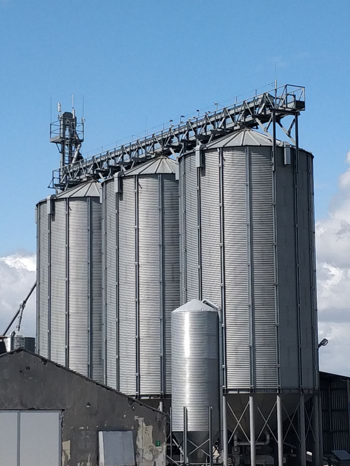 Crafting Captivating Headlines: Your awesome post title goes here Large metal grain storage silos under a clear blue sky, representing agriculture.